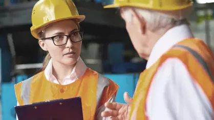 image of a man and woman with yellow helmets talking
