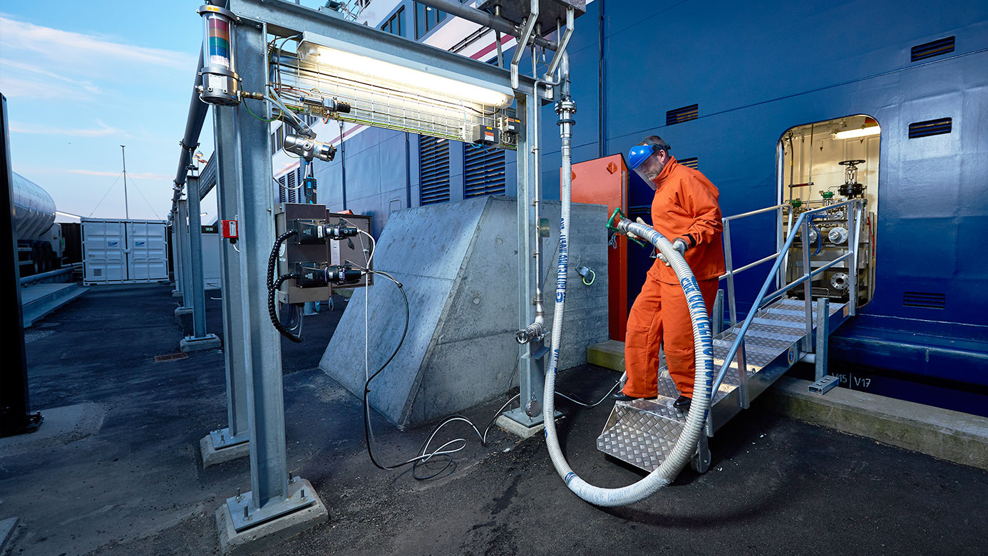 image of a man in orange bunkering a ship