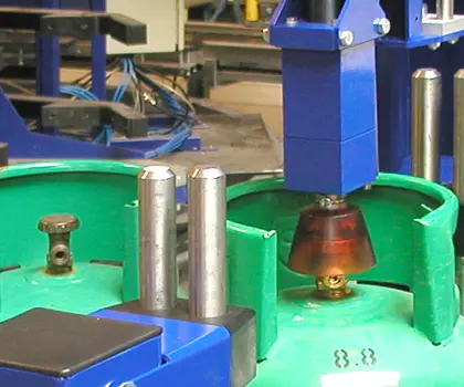 closeup of a valve opener and closer on a blue machine handling a green lpg cylinder