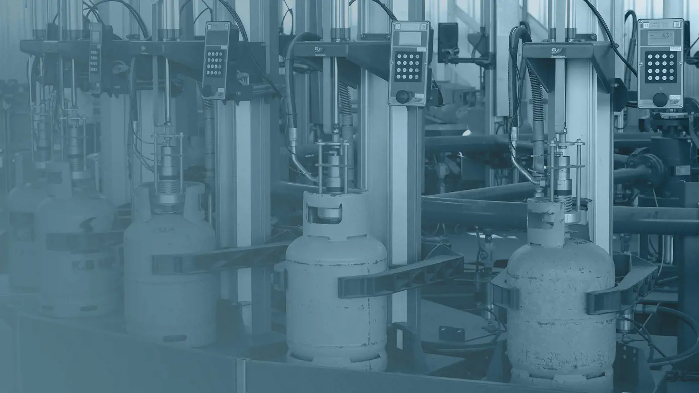 blue toned image of lpg cylinders on a filling carrousel
