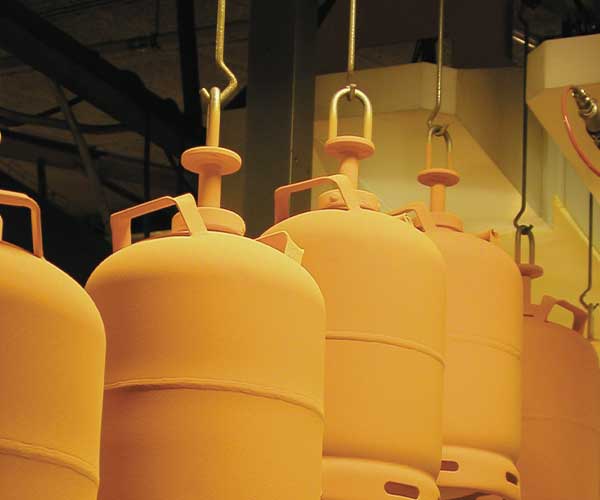 Freshly painted yellow LPG cylinders hanging on hooks
