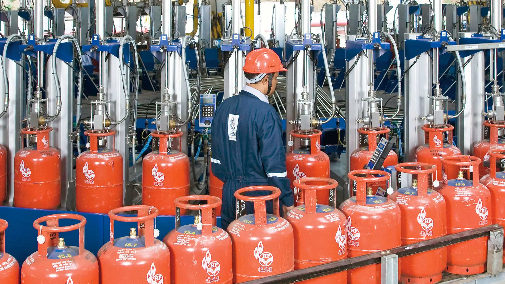 Operator overseeing red LPG cylinders being filled on a FLEXSPEED carrousel