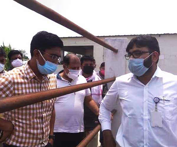 A group of men wearing face masks and inspecting an oxygen plant