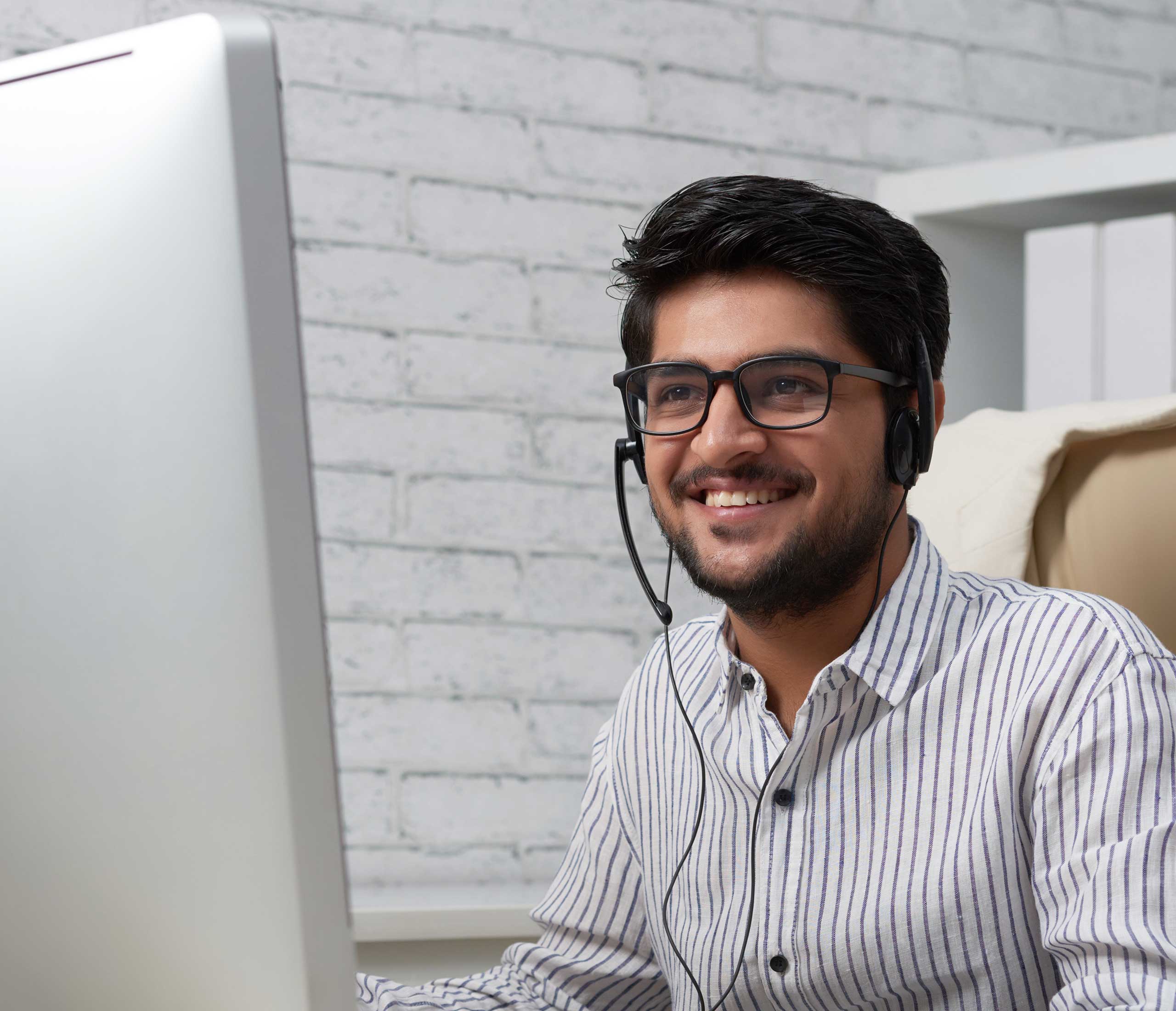 Young man working at a desk, wearing headset