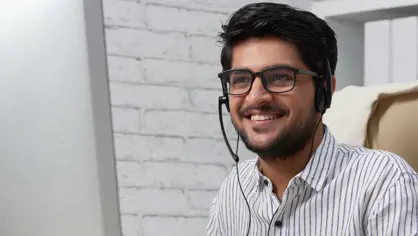 Young man working at a desk, wearing headset