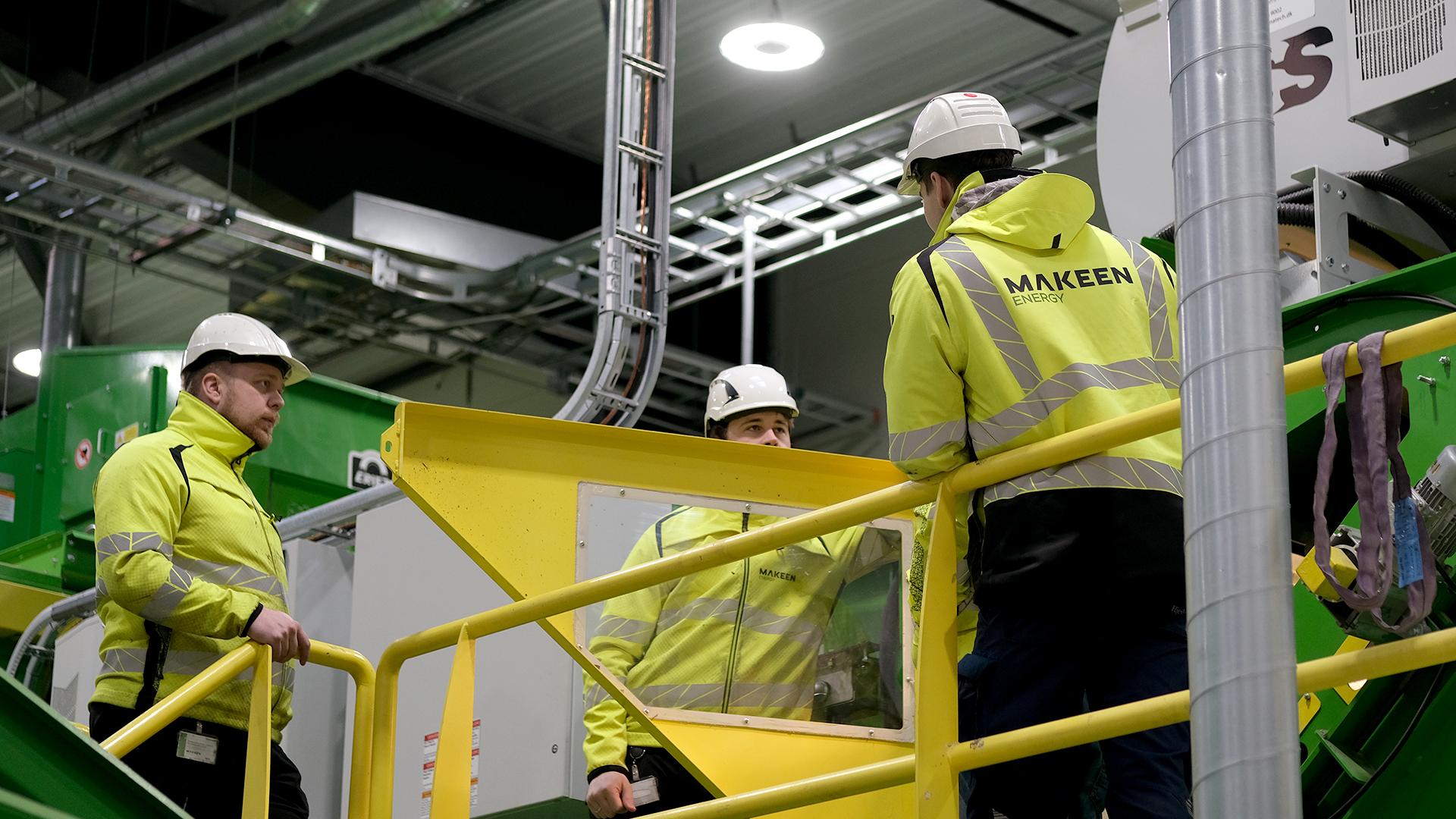 three MAKEEN Energy employees standing with a machine