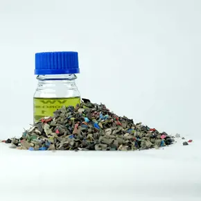 image of a glas with oil and a pile of shredded old plastic waste