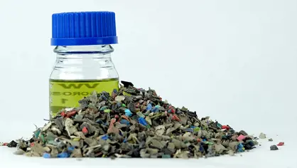 image of a glas with oil and a pile of shredded old plastic waste