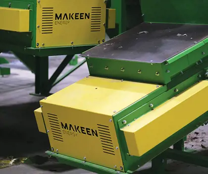 Image of a part of Plastcon One facility machine yellow metal plate with the MAKEEN Energy logo
