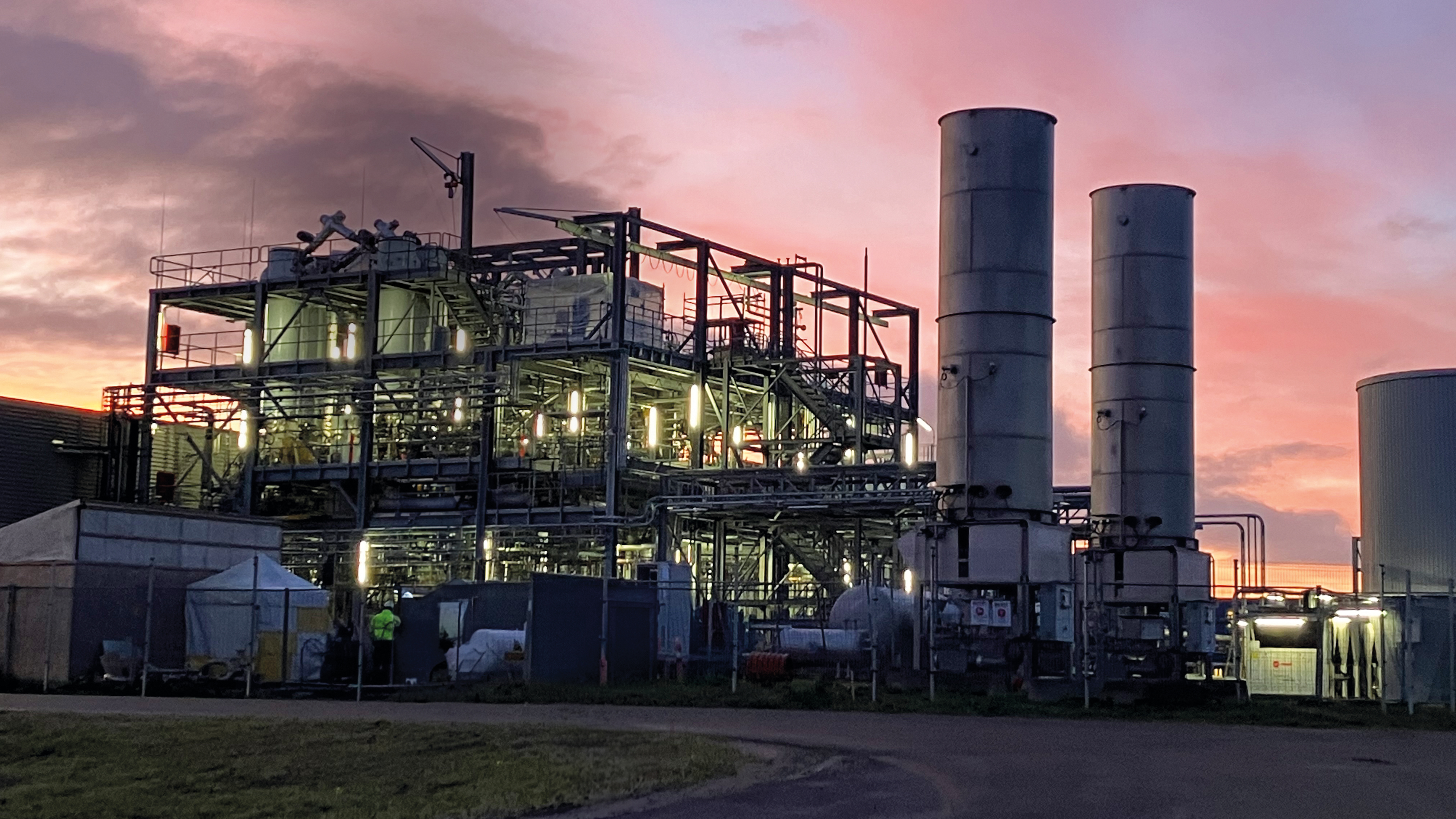 image of a plastic waste conversion plant in sunset pipings and silos
