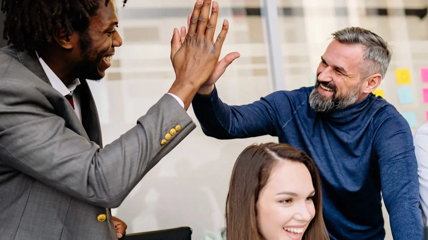 Team members high fiving during a project
