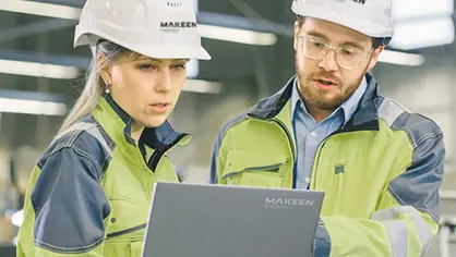 image of a man and woman in yellow jackets with white helmets holding a computer and talking