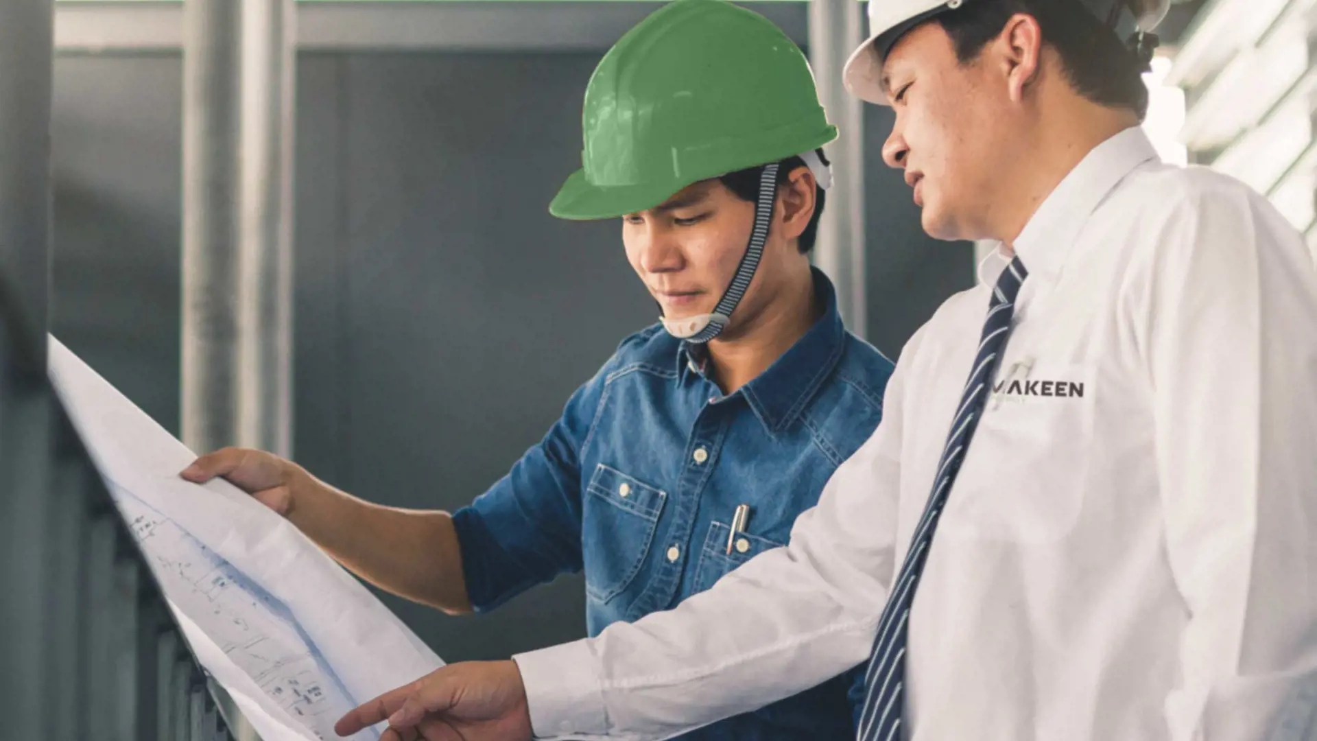 image of to men with helmets looking at a technical drawing