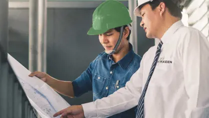 image of to men with helmets looking at a technical drawing