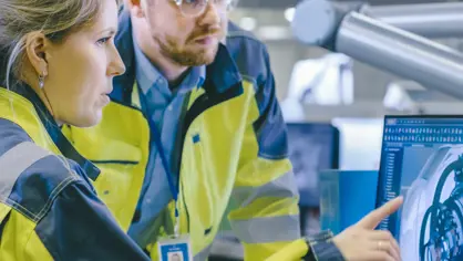 Man and woman looking at 3D models of machinery on a screen