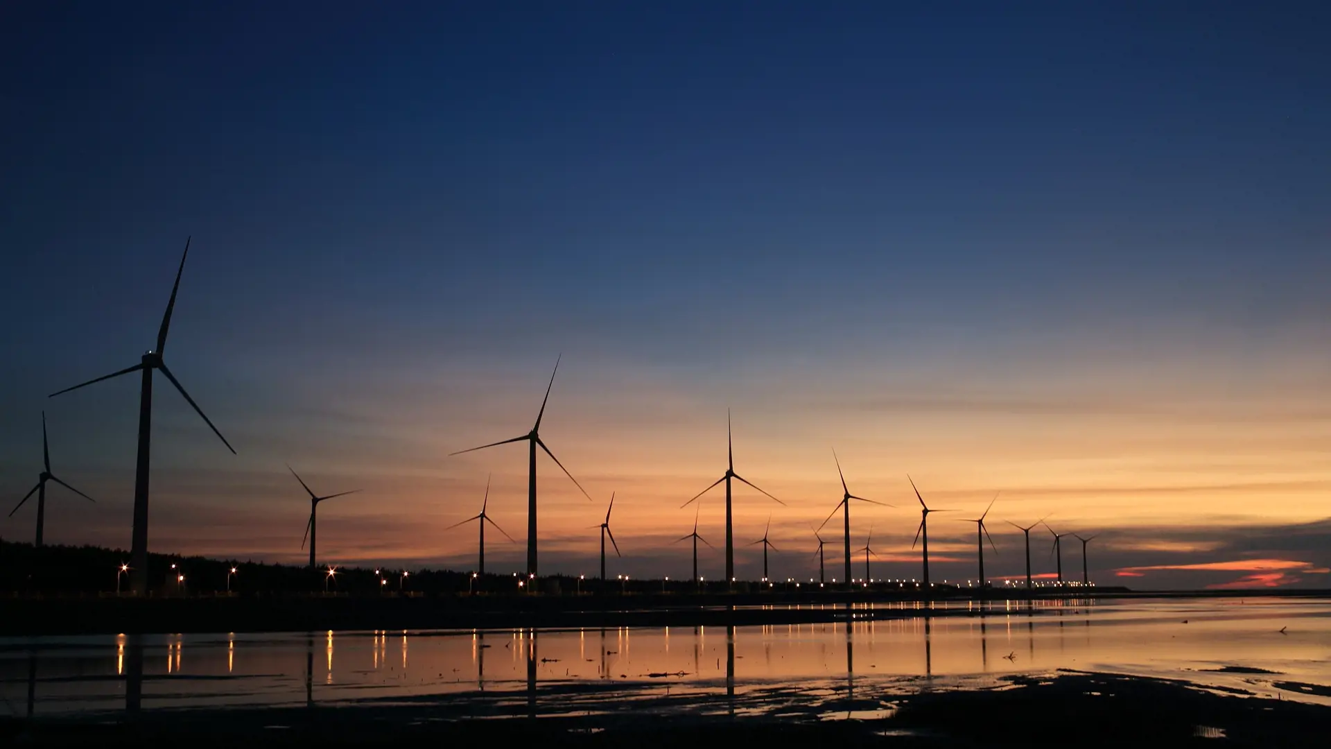 Coastal wind turbine farm at sunset