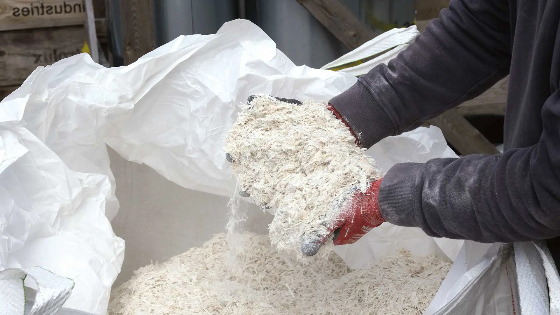 Shredded glass fibre being held by an unseen person