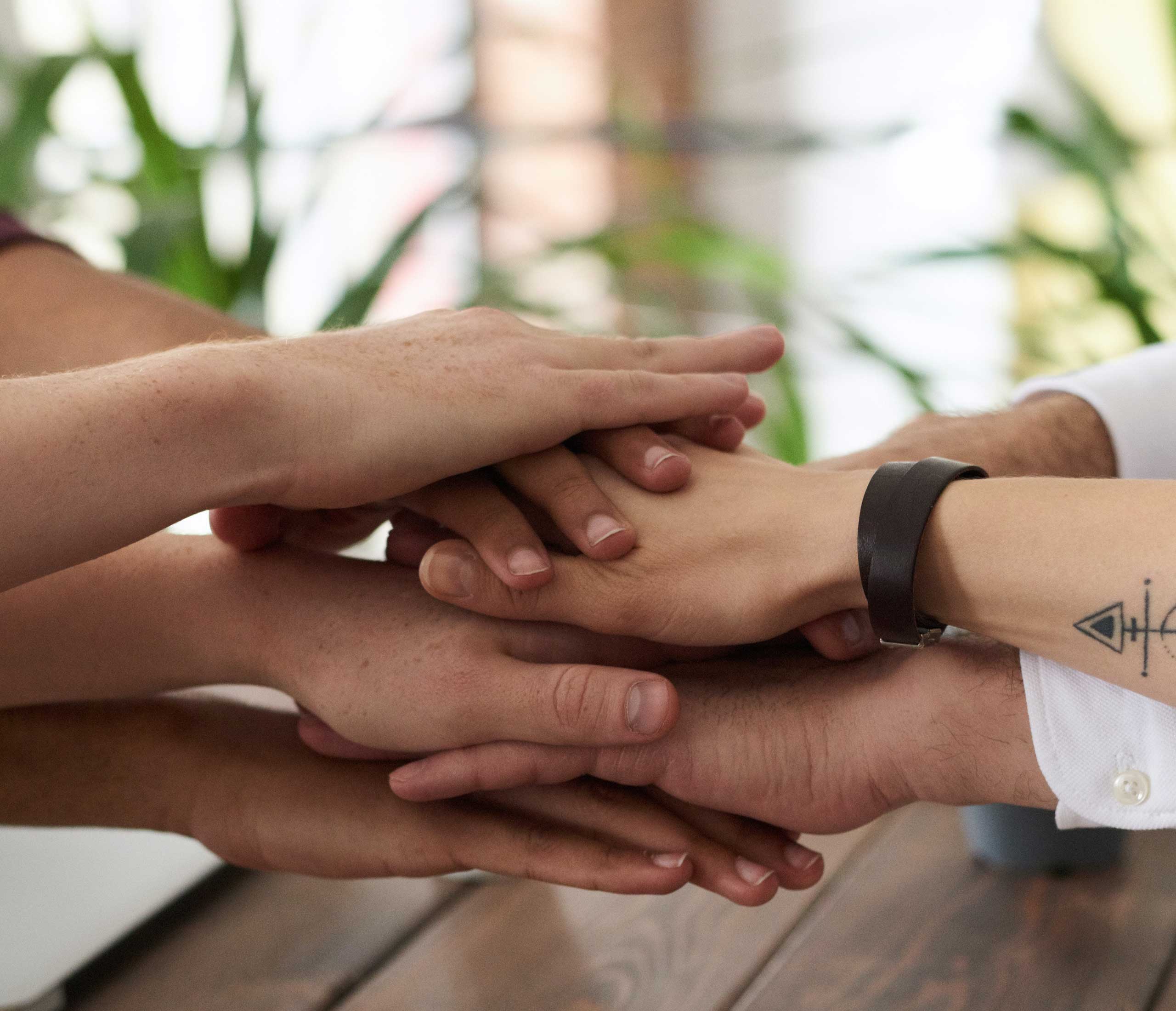 Multiple hands coming together over a table